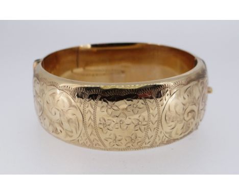 9CT GOLD BANGLE, scroll engraved, 33.0gms