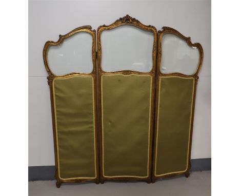An Art Nouveau trifold folding screen, around 1900. Gilded wooden frame with carved floral motif, facet cut glass and green l