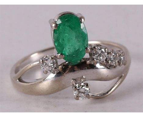 An 18 kt 750/1000 gold ring with an oval facet cut emerald and 5 diamonds, ring size Ø16.5 mm.