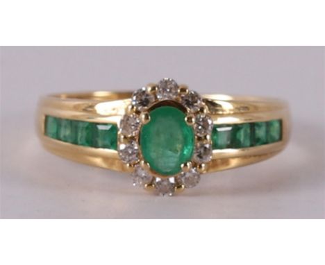 An 18 kt 750/1000 gold ring with 10 brilliant cut diamonds of a total of 0.30 crt H-SI, 1 oval and 8 princess cut emeralds, r