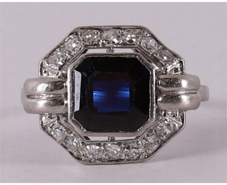 A platinum, 850/1000 Art Deco ring with a facet cut blue sapphire and 14 octagon cut diamonds of a total of 0.56 crt, ring si