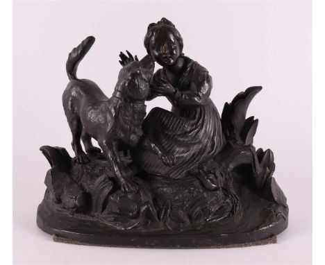 A bronze sculpture of a sitting girl with dog, around 1900, h 16.5 x w 20 cm.