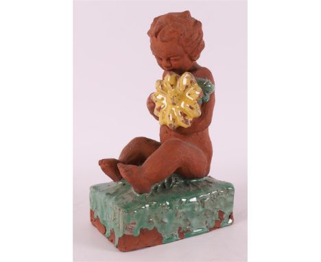 A brown ceramic putto with flower, Germany, ca. 1925. Unclearly signed on the bottom, h 18.5 x w 11 x d 8 cm.