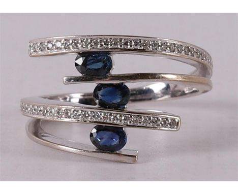 An 18 kt 750/1000 gold ring with 3 oval facet cut blue sapphires and 30 brilliants, ring size Ø 17.5 mm.