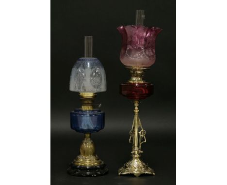 An oil lamp,with etched pink shade and cranberry glass reservoir, on an Aesthetic brass column,72cm high, and another oil lam
