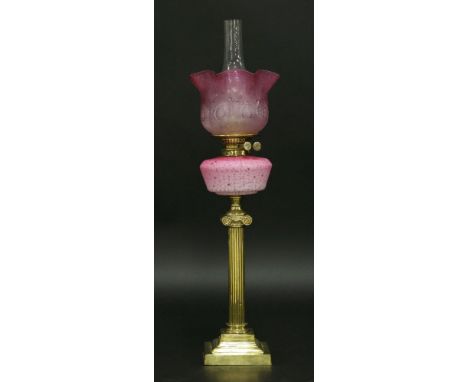 An oil lamp,with etched pink shade, mottled pink glass font on brass Ionic column,79cm high