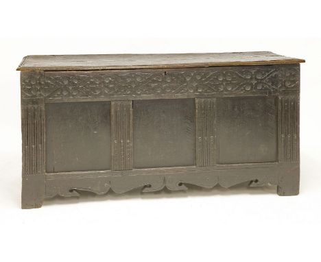 A large oak coffer,17th century, the plank top with original wire hinges over a carved three-panel front,145cm wide59cm deep7