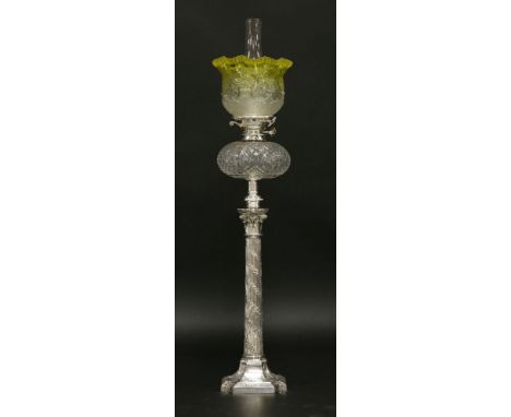 An oil lamp,with etched, moulded and yellow-tinted grille shade, on a silver-plated Corinthian column,98cm high