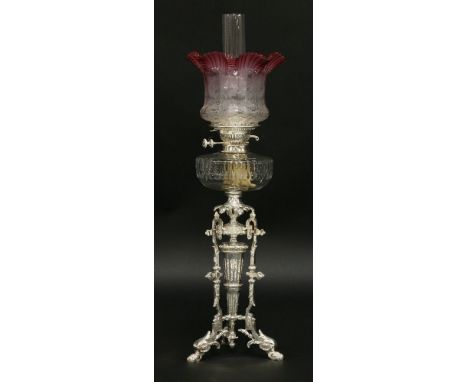 An oil lamp,with etched cranberry grille shade, Duplex No. 2 burner and cut glass reservoir, on a silver-plated triform pan b