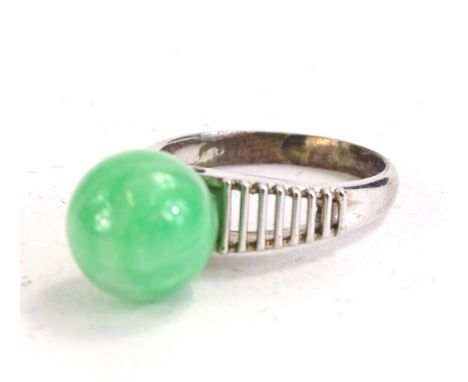 A dress ring, set with polished jade stone, on a silver plated band, with Chinese markings, boxed.