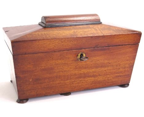 A mid 19thC mahogany sarcophagus shaped tea caddy, the hinged lid enclosing two covers, on bun feet, 25cm wide