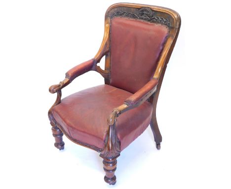A Victorian walnut open armchair, the back carved with the crest for East Retford, with a leathered padded back arm rest and 