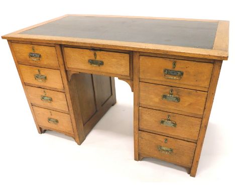 A Victorian oak kneehole desk, with an arrangement of nine drawers each with brass handles, 120cm W.