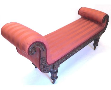 A 19thC mahogany chaise lounge, upholstered in striped coral coloured fabric carved overall with laurel leaves and acanthus o