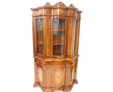 An Italian walnut and marquetry display cabinet, the crest with carved wood shells etc above a marquetry frieze and a central