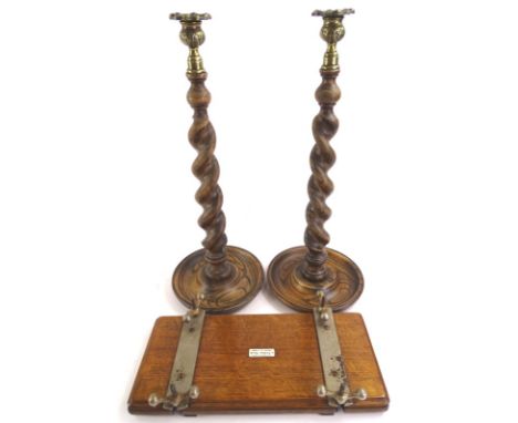 A pair of early 20thC ebonised oak spirally turned candlesticks, with brass mounts, 46cm high and an Averitt's tie press (3)