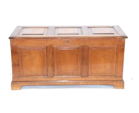 Period Oak Reproductions Ltd: A Panelled Oak Chest, the hinged lid enclosing a vacant interior with moulded base and bracket 