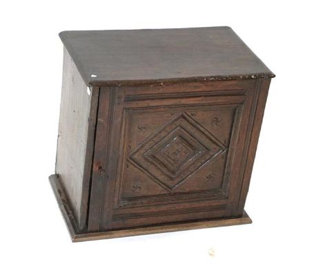 ~ A Late 17th Century Wall-Mounted Oak Mural Cupboard, the moulded door carved with a lozenge, enclosing an adjustable shelf,