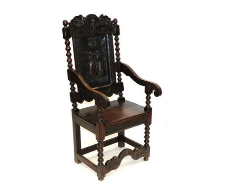 A Victorian Joined Oak Armchair, mid 19th century, the carved top rail above a relief carved panel between bobbin turned supp