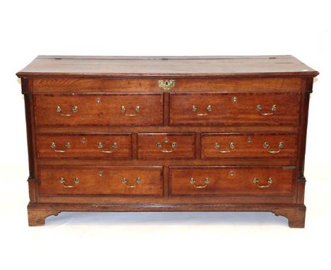 A George III Lancashire Oak and Mahogany Crossbanded Mule Chest, the hinged lid above two dummy drawers with five real drawer