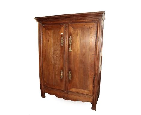 An 18th Century French Provincial Chestnut Armoire, the moulded cornice above double doors with brass escutcheons, the interi