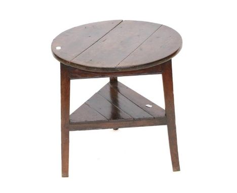 A George III Oak Circular Cricket Table, early 19th century, the three-plank top above a triangular frame, on chamfered legs 