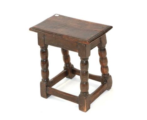 ~ A Late 17th Century Oak Joint Stool, of peg and nail construction, the moulded top above a plain frieze, on bobbin turned l