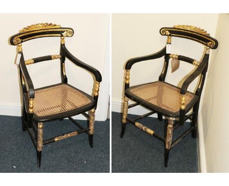 A Pair of Regency-Style Ebonised and Parcel Gilt Armchairs, late 19th century, the carved top rails above reeded and turned h