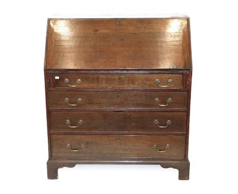 A Mid 18th Century Oak Bureau, the fall front enclosing pigeon holes, small drawers and a cupboard door above four pine-lined