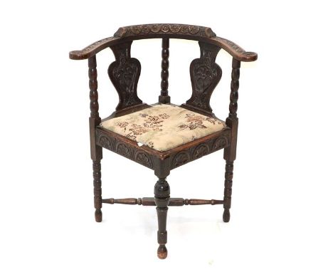 ~ A Victorian Carved Oak Corner Elbow Chair, mid 19th century, the guilloche carved top rail and double carved solid splats a