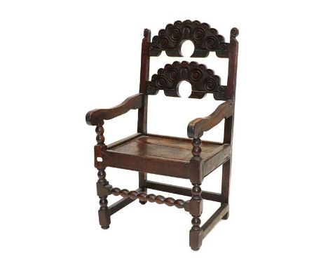 A 17th Century Joined Oak Armchair, South Yorkshire, with double crescent carved back support and boarded seat, on turned and