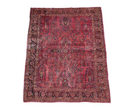 Saroukh CarpetWest Iran, circa 1930The faded strawberry field of angular plants around a cruciform medallion framed by indigo
