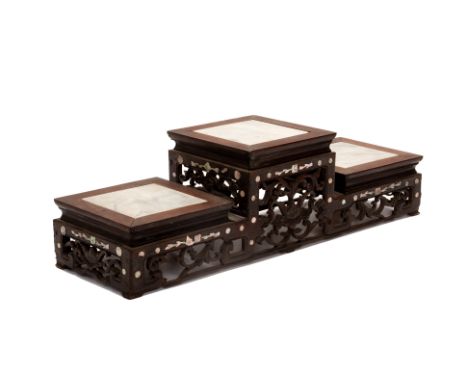 A MARBLE INSET THREE TIER CARVED WOOD STAND
The sides carved and pierced with foliate decoration and inlaid with further moth