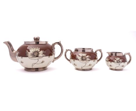 A Gibson & Sons pottery three piece Silvor Art Ware tea service, decorated with a band of ivory blooms and silver lustre, pri