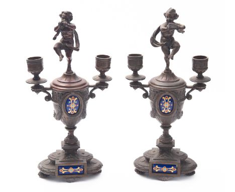 A pair of spelter and enamelled twin light candelabra; late 19th century; each surmounted by a dancing Pan figure, above twin