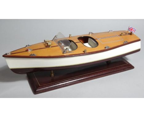 A 20thC wooden model of a speed boat, with realistic decking, on polished plinth base, 50cm wide.