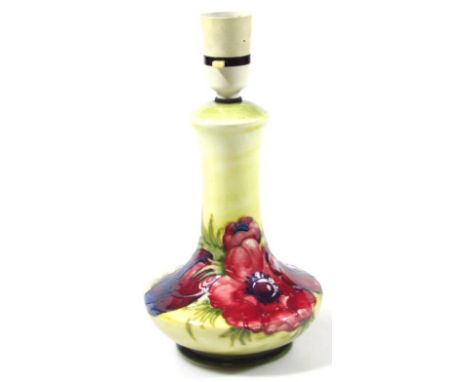 An early 20thC Moorcroft lamp, of bellied form, anemone pattern, on yellow ground, on circular foot, with impressed marks and