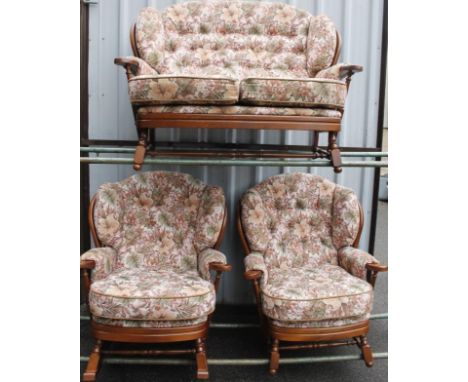 An Ercol style cottage suite, comprising two seater settee, 125cm wide, and two wing armchairs, each in button back floral ma