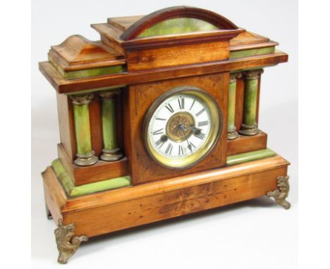 An early 20thC carved wooden mantel clock, the 11cm dia. dial with Roman numerals revealing an eight day movement fitted in a