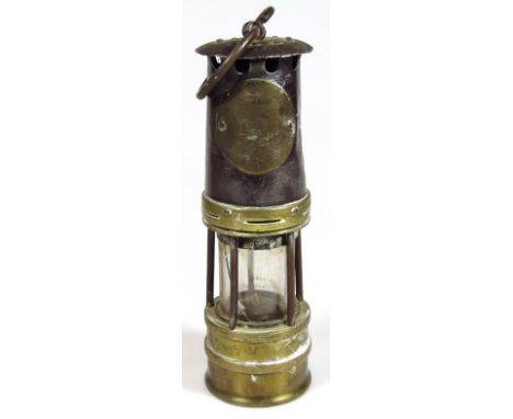 A mid 20thC miner's lamp, partially number 48, of cylindrical outline with central glass section and 'S' hook top, 29cm high.