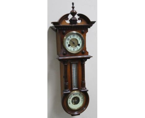 A late 19thC walnut cased barometer thermometer and clock, probably by Gustav Becker, in a carved case with 10cm dia. dial re