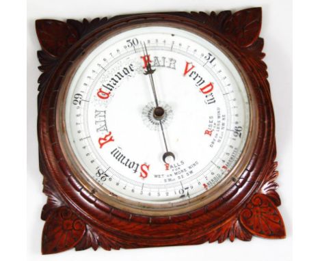 An early 20thC oak cased wall barometer, with 20cm dia. dial in heavily carved case with floral spandrels.