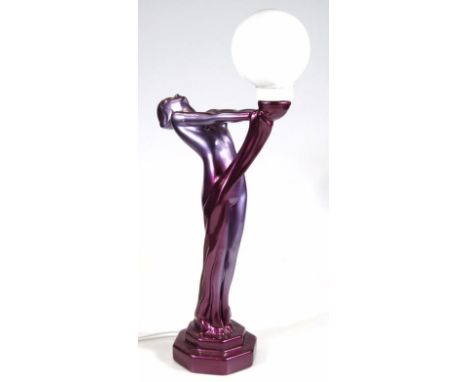 A modern Deco style table lamp, formed as a semi-clad lady holding a globe, on stepped base in purple with milk glass shade, 