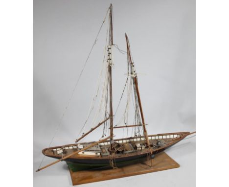 A table top scale model of wooden masted yacht clipper, with realistic decking and masts, on a wooden plinth base.