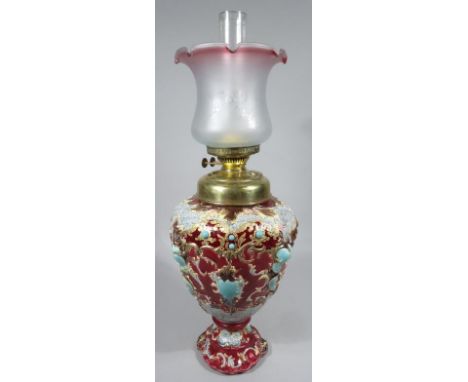 An early 20thC Continental majolica table lamp, with frosted clear and pink glass shade, clear funnel, brass top and vase bod