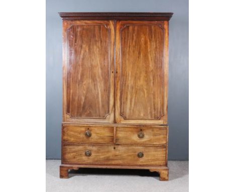 A George III Gentleman's Mahogany Wardrobe, the upper part with moulded and dentil cornice, fitted five sliding trays enclose