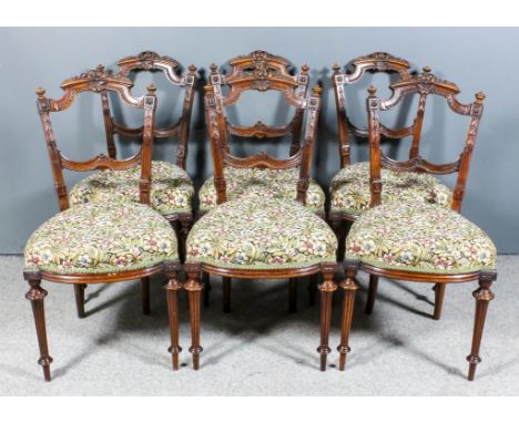 A Set of Six Late Victorian Walnut Drawing Room Chairs, the ornate shaped and moulded backs with turned finials and fluted up