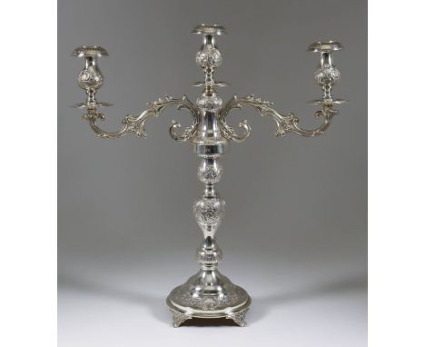 A George V Silver Three Light Candelabra, by Joseph Sweig, London 1920, the whole embossed with leaf scroll ornament and with