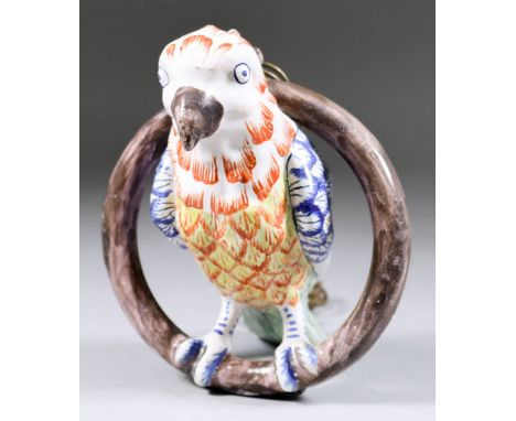 A Dutch Delft Model of a Parrot on a Ring Perch, 18th/19th Century, the moulded detail picked out in colours, 7.25ins high, w