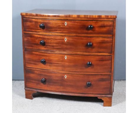 A Late Georgian Mahogany Bow Front Chest, with square edges, fitted four long graduated drawers with turned ebonised knob han